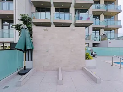 a building with a green umbrella in a courtyard at Spacious 2-Bedroom Apartment in Al Furjan-1010 in Dubai