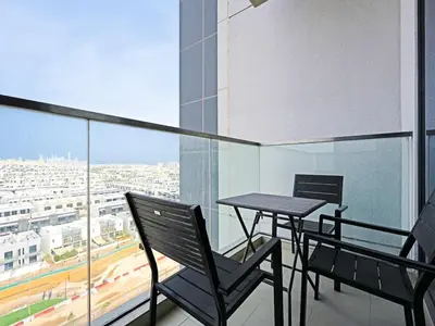 a balcony with a table and chairs on a building at Spacious 2-Bedroom Apartment in Al Furjan-1010 in Dubai