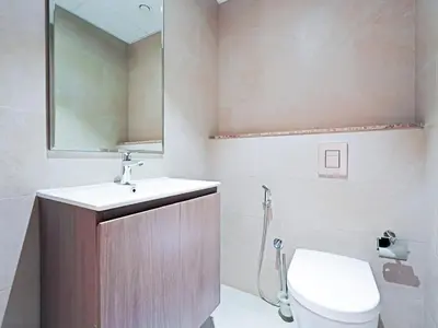 a bathroom with a toilet and a sink and a mirror at Spacious 2-Bedroom Apartment in Al Furjan-1010 in Dubai