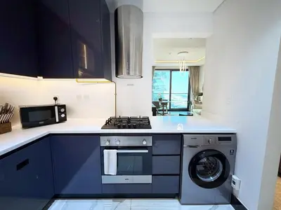 a kitchen with a stove and a washing machine at Premium Luxury 2BR Business Bay - Valet parking, Pool, Gym, SPA and Ice room in Dubai