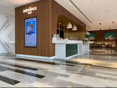 a large lobby with a counter in a building at Vogue JVT Novotel Near Springs Souk Mall, One Bedroom Apartment with Large Balcony and Vibrant Community view, Access to all Amenities in Dubai