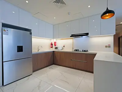 a kitchen with a refrigerator and a sink at Well-Maintained 2-Bedroom Home in Community-410 in Dubai