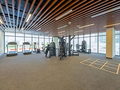 a gym with cardio equipment in a large room with windows at Well-Maintained 2-Bedroom Home in Community-410 in Dubai