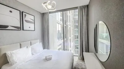 a bedroom with a white bed and a large window at STAY BY LATINEM Luxury 1BR Holiday Home CVR A 1410 near Downtown in Dubai