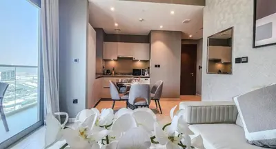 a living room with a couch and a table with chairs at STAY BY LATINEM Luxury 1BR Holiday Home CVR A 1410 near Downtown in Dubai
