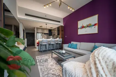 a living room with purple walls and a couch and a table at High Floor With Full Lake View in Dubai