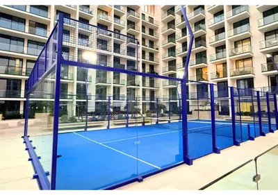 a tennis court in front of a building at Chic Modern Studio Unit in JVC with 65 inch TV in Dubai
