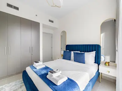 a bedroom with a blue and white bed with towels on it at Brand New & Welcoming 2BDR In Forte Downtown 34 in Dubai
