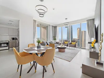 a kitchen and living room with a table and chairs at Brand New & Welcoming 2BDR In Forte Downtown 34 in Dubai