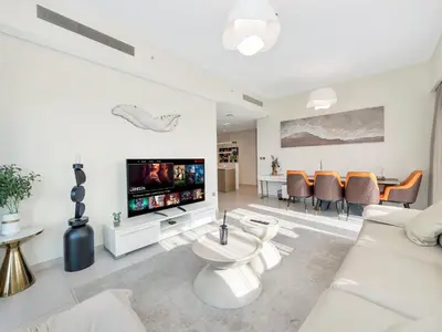 a living room with a white couch and a tv at Burj Royale Collection by The Luxe Manor - Downtown Dubai in Dubai