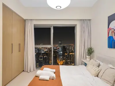 a bedroom with a large window with a city skyline at Burj Royale Collection by The Luxe Manor - Downtown Dubai in Dubai
