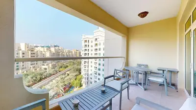 a balcony with two tables and chairs and a large window at Vacationer l 1 Bed on The Palm l City Views l Near Atlantis in Dubai