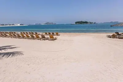a group of lounge chairs on a beach at Vacationer l 1 Bed on The Palm l City Views l Near Atlantis in Dubai