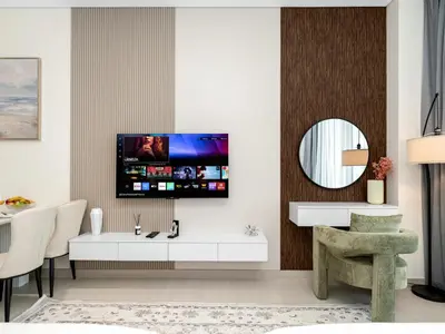 a living room with a tv on a wall at Cozy Studio with Balcony and Jacuzzi I Near Dubai Mall & Downtown I Sleeps 4 in Dubai