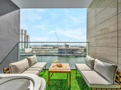 a balcony with chairs and a table and water at Cozy Studio with Balcony and Jacuzzi I Near Dubai Mall & Downtown I Sleeps 4 in Dubai