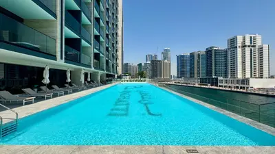 a swimming pool with a city skyline in the background at Cozy Studio with Balcony and Jacuzzi I Near Dubai Mall & Downtown I Sleeps 4 in Dubai
