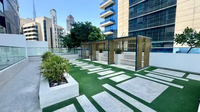 a courtyard on a building with grass and plants at Cozy Studio with Balcony and Jacuzzi I Near Dubai Mall & Downtown I Sleeps 4 in Dubai