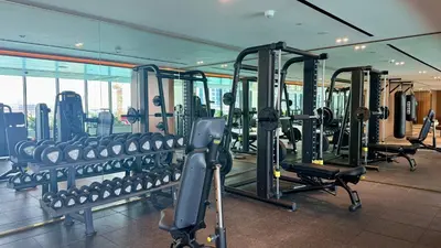 a gym with rows of tread machines in a building at Cozy Studio with Balcony and Jacuzzi I Near Dubai Mall & Downtown I Sleeps 4 in Dubai