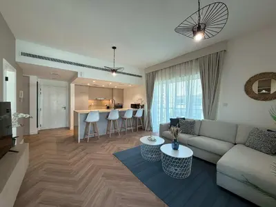 a living room with a couch and a table at High End Upgraded 1BR Living in The Greens in Dubai