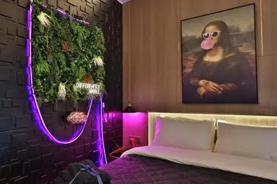 a bedroom with a bed with a painting and purple lights at The Eden Suite Modern Luxury Meets Cozy Comfort in Dubai