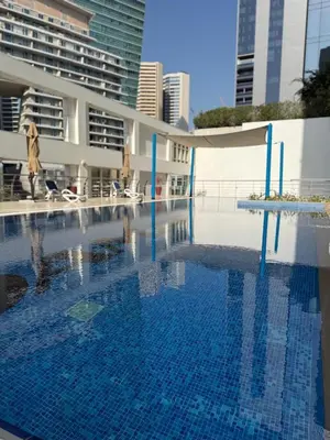 a large blue swimming pool in front of a building at Fully Luxury Studio Total Privacy Pool & Sauna in Dubai
