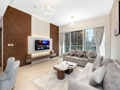 a living room with a couch and a tv at EMAAR GRANDE - Cozy 1 Bedroom Apartment - Infinity Pool - 1min to Dubai Mall and Burj Khalifa in Dubai