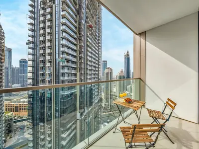 a balcony with a table and chairs and a view of the city at EMAAR GRANDE - Cozy 1 Bedroom Apartment - Infinity Pool - 1min to Dubai Mall and Burj Khalifa in Dubai