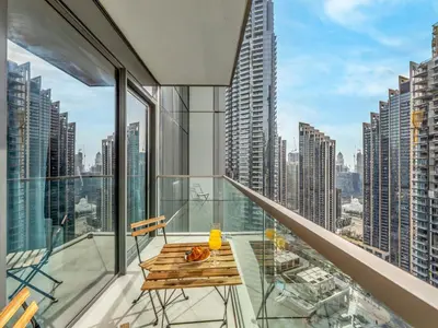 a balcony with a table and chairs and a view of a city at EMAAR GRANDE - Cozy 1 Bedroom Apartment - Infinity Pool - 1min to Dubai Mall and Burj Khalifa in Dubai