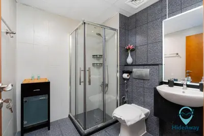 a bathroom with a shower and a toilet and a sink at Elegant 1BR l Steps to Metro l Free Parking in Dubai