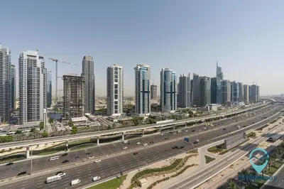 a highway in front of a city with tall buildings at Elegant 1BR l Steps to Metro l Free Parking in Dubai