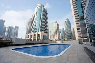 a swimming pool in a city with tall buildings at Elegant 1BR l Steps to Metro l Free Parking in Dubai