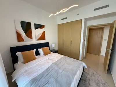 a bedroom with a large bed and paintings on the wall at 17 Icon Bay Creek Harbour in Dubai