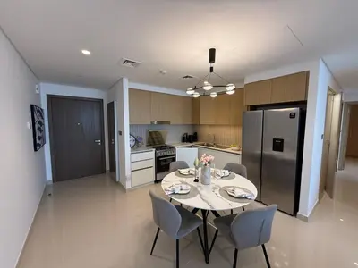 a kitchen with a table and chairs and a refrigerator at 17 Icon Bay Creek Harbour in Dubai