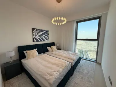 a bedroom with a large bed with a large window at 17 Icon Bay Creek Harbour in Dubai