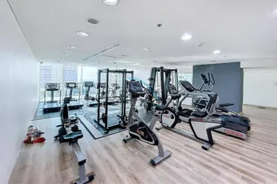 a gym with several tread machines in a room at Penthouse with panoramic water-view Ultra-luxury in Dubai