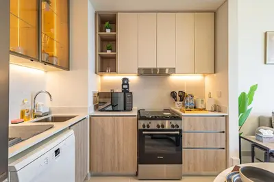 a kitchen with white cabinets and a stove top oven at Superhost - 1BR Apartment , Pool & Gym , Near Dubai Hills Mall in Dubai