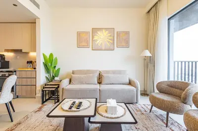 a living room with a couch and a table at Superhost - 1BR Apartment , Pool & Gym , Near Dubai Hills Mall in Dubai