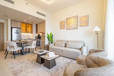 a living room with a couch and a table at Superhost - 1BR Apartment , Pool & Gym , Near Dubai Hills Mall in Dubai