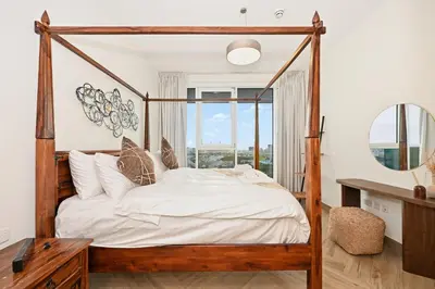 a bedroom with a wooden canopy bed with a mirror at Bloomfields Luxurious 3BR in West Residences in Dubai