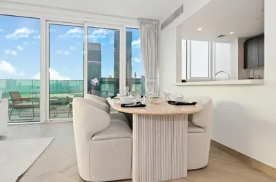 a kitchen with a table and chairs and a large window at Bloomfields Luxurious 3BR in West Residences in Dubai