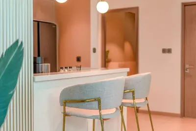 two chairs sitting next to a counter in a kitchen at TRPS - Act Towers, Downtown Dubai - Full Burj Khalifa View, High-End 3BR plus Maids in Dubai