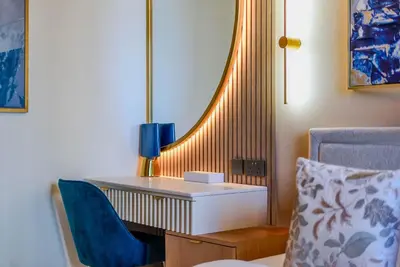a desk with a lamp and a chair in a room at TRPS - Act Towers, Downtown Dubai - Full Burj Khalifa View, High-End 3BR plus Maids in Dubai