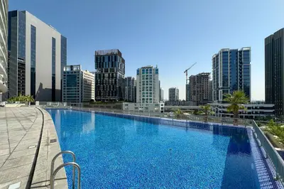 a large swimming pool with a city skyline in the background at Modern Smart & Spacious 1BR Business Bay near Downtown Dubai in Dubai