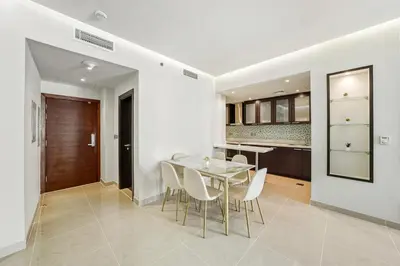 a kitchen and dining room with a glass table and chairs at Modern Smart & Spacious 1BR Business Bay near Downtown Dubai in Dubai