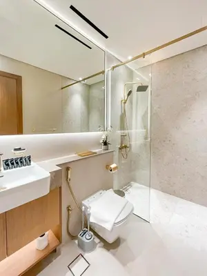 a bathroom with a shower and a toilet and a sink at Soft-Toned 1BR in Binghatti Gardenia with Pool & Gym in Dubai
