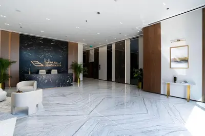 a lobby with a large marble floor and a reception desk at Soft-Toned 1BR in Binghatti Gardenia with Pool & Gym in Dubai