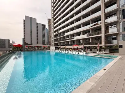 a large swimming pool in front of a building at GuestReady - Prime Location | Studio Canal View in Dubai