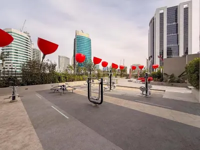 a parking lot with red umbrellas in a city at GuestReady - Prime Location | Studio Canal View in Dubai