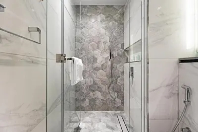 a bathroom with a shower with a glass door at GuestReady - Prime Location | Studio Canal View in Dubai