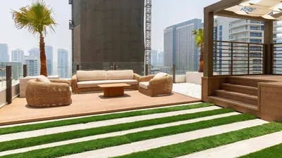 a patio with a couch and a table on a balcony at Maison Privee - Ultimate Luxury Penthouse with Pool & Marina Views in Dubai